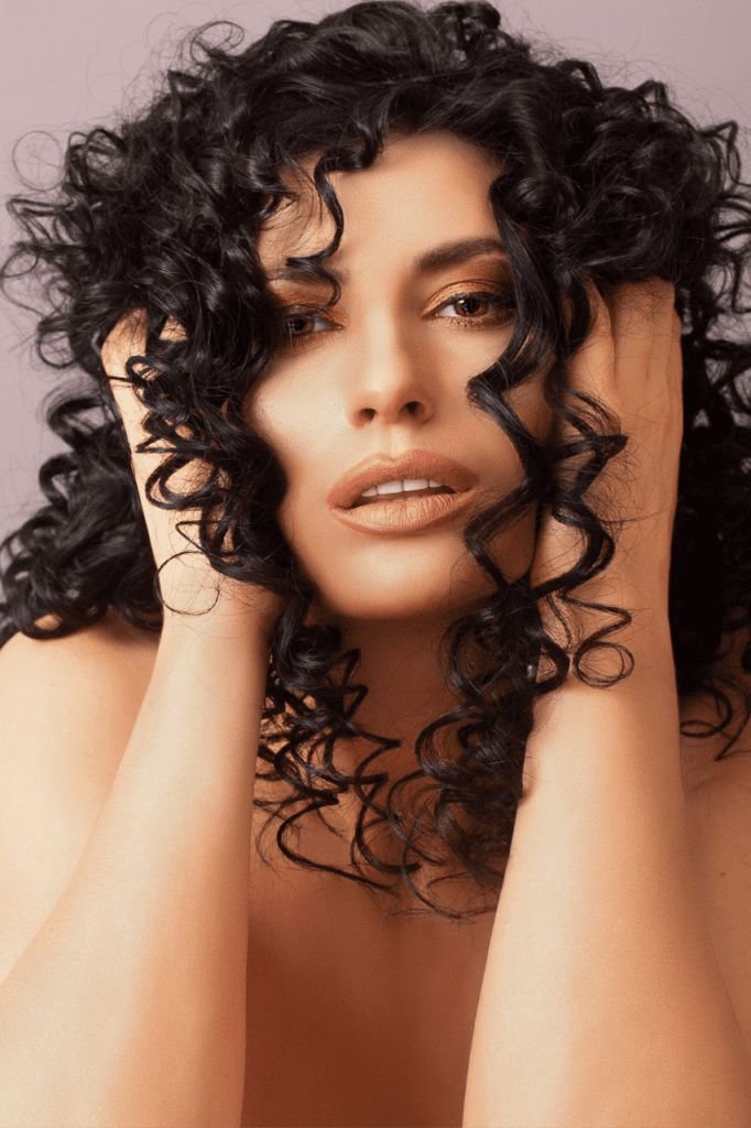 Woman with defined dark curls, shaped by a Roseville curly hair specialist