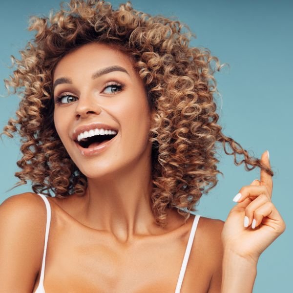 Laughing woman with bouncy curly hair after a curly haircut in Roseville
