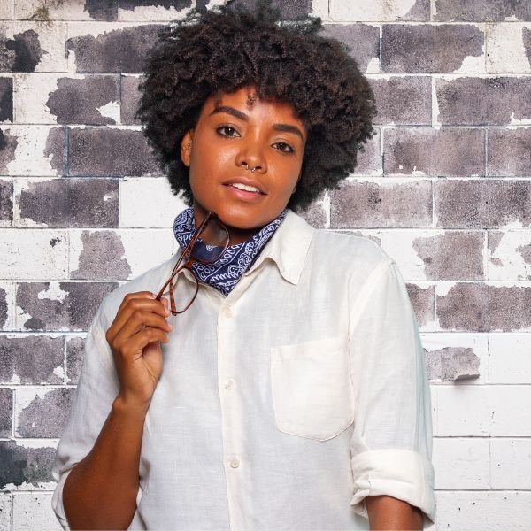 Woman with natural textured hair styled in a white shirt